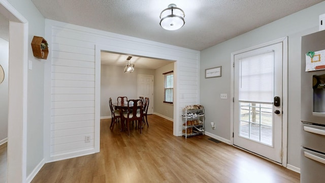 entryway featuring a textured ceiling and light hardwood / wood-style flooring