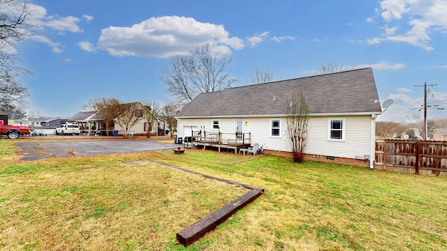 back of house with a lawn and a deck