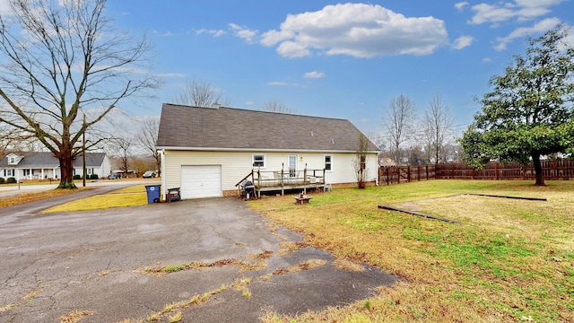 back of house featuring a deck, a yard, and a garage