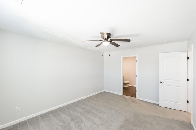 unfurnished bedroom with ceiling fan, light colored carpet, and ensuite bath