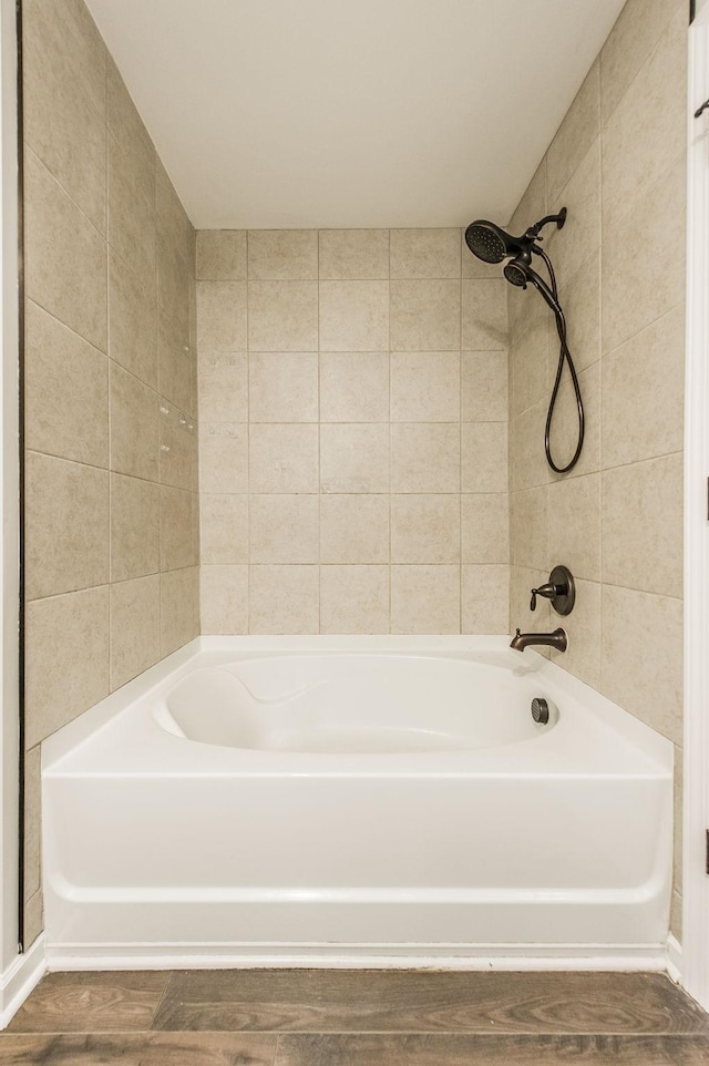 bathroom with tiled shower / bath combo and hardwood / wood-style flooring