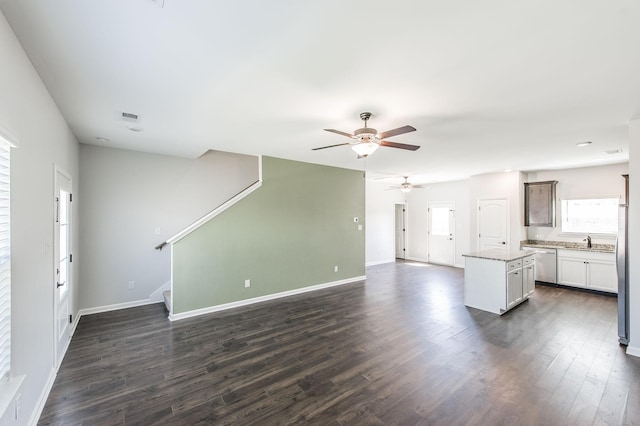 unfurnished living room featuring ceiling fan, dark hardwood / wood-style floors, and sink