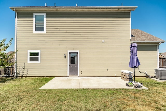 rear view of property featuring central AC, a lawn, and a patio