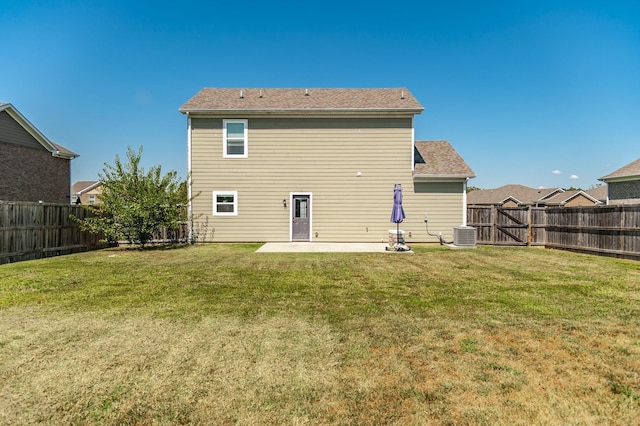 rear view of property with a yard, central AC unit, and a patio