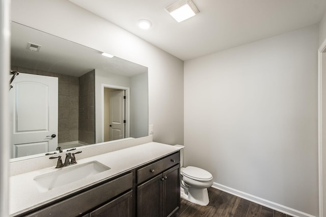 bathroom featuring toilet, vanity, a washtub, and hardwood / wood-style floors