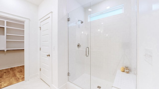 bathroom with wood-type flooring and an enclosed shower