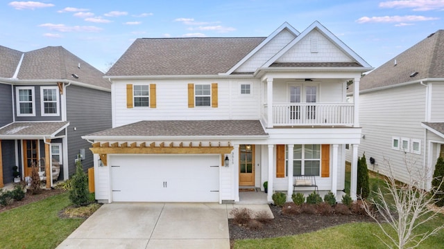 view of front facade with a balcony, a garage, a porch, and a front yard