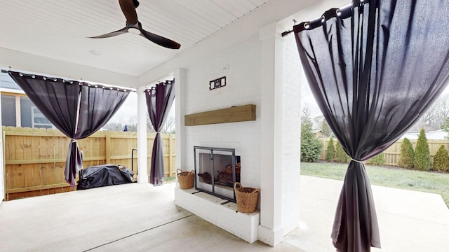 view of patio with an outdoor brick fireplace and ceiling fan