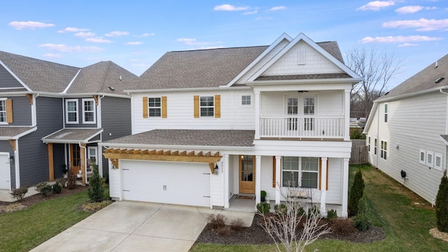 view of front of property featuring a balcony, a garage, and a front yard