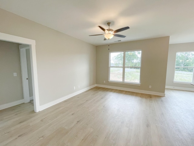 empty room featuring light wood-type flooring, ceiling fan, and a wealth of natural light