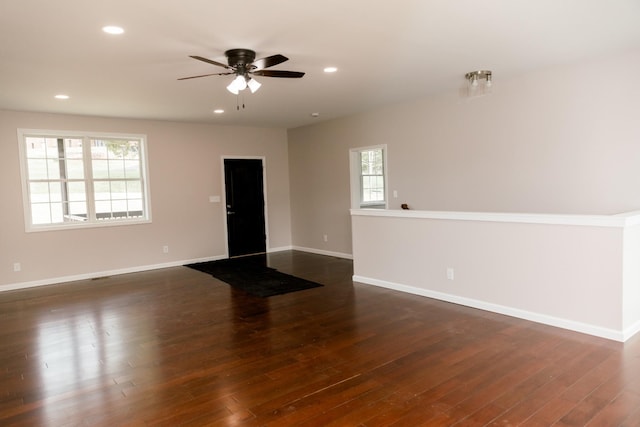 empty room with a ceiling fan, dark wood-type flooring, recessed lighting, and baseboards