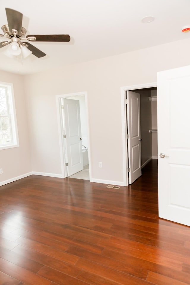 interior space featuring visible vents, baseboards, wood finished floors, and a ceiling fan