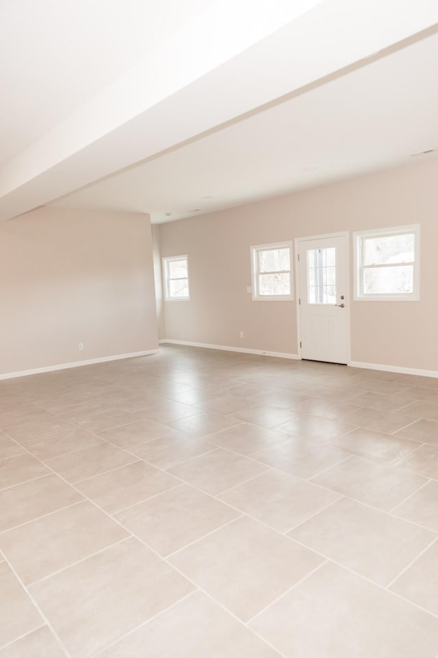 unfurnished room featuring baseboards and light tile patterned flooring