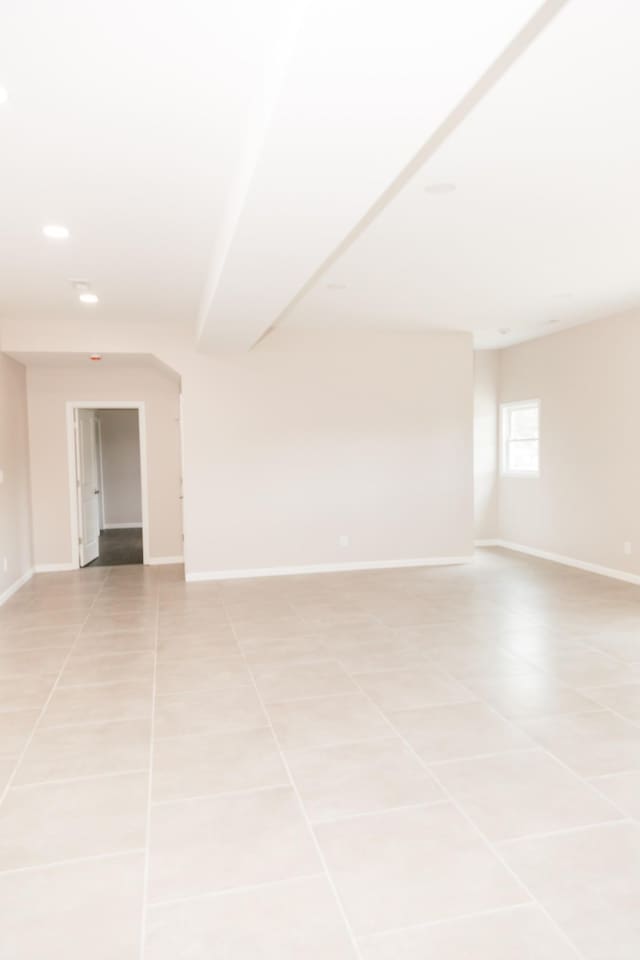 spare room featuring light tile patterned floors, recessed lighting, and baseboards