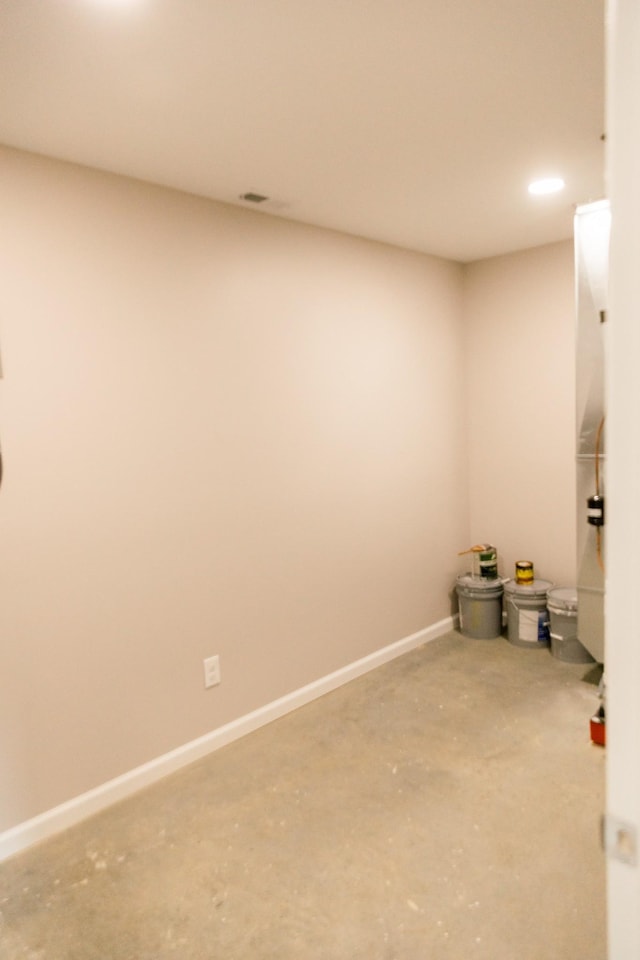 unfurnished room featuring baseboards and concrete flooring