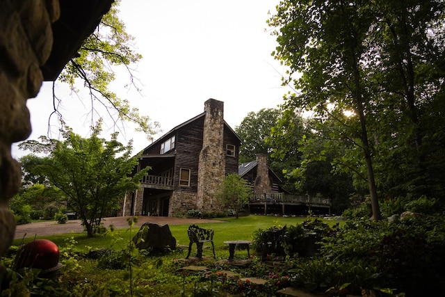 back of property featuring a lawn and a deck