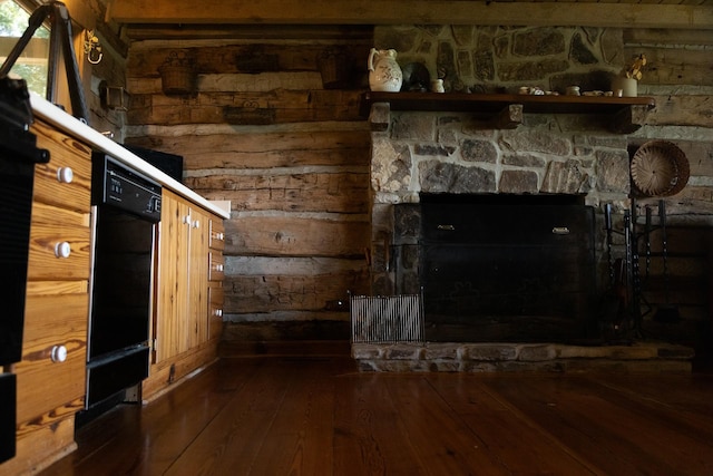 interior space with dark wood-type flooring and a stone fireplace