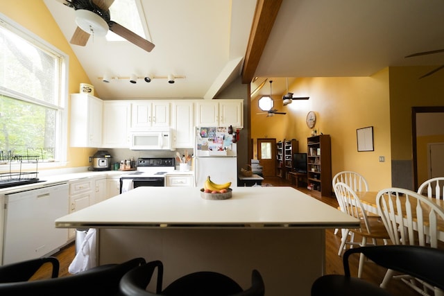 kitchen with white appliances, white cabinets, a center island, lofted ceiling with beams, and ceiling fan