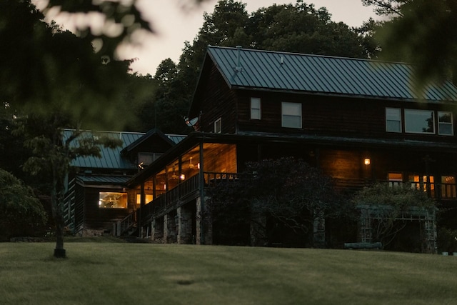 back house at dusk featuring a yard