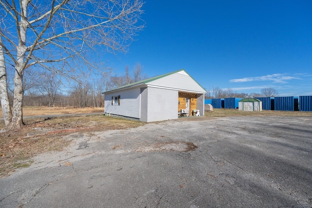 view of side of home featuring a storage unit