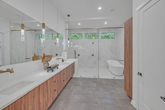 bathroom featuring a sink, a freestanding bath, a marble finish shower, and double vanity