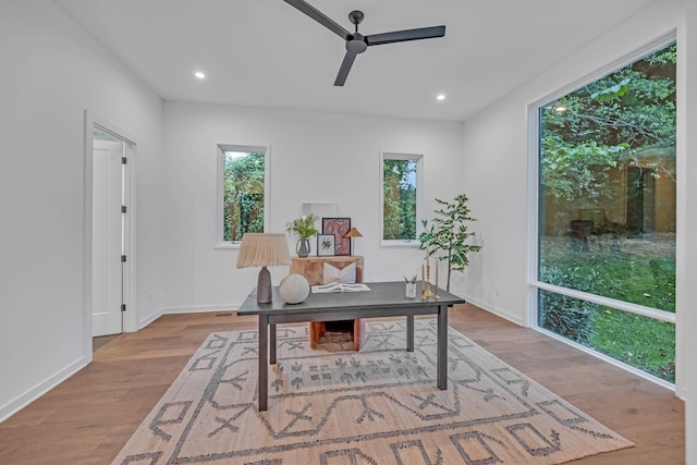 office space with plenty of natural light, a ceiling fan, wood finished floors, and recessed lighting