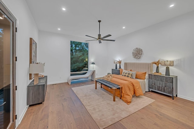 bedroom with baseboards, wood finished floors, and recessed lighting