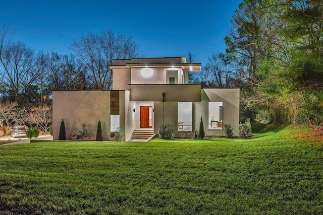 contemporary house with a front yard and stucco siding