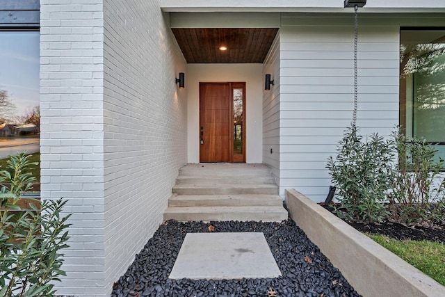 view of exterior entry featuring brick siding