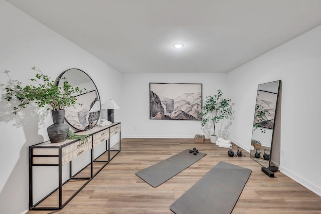 exercise room featuring baseboards and wood finished floors