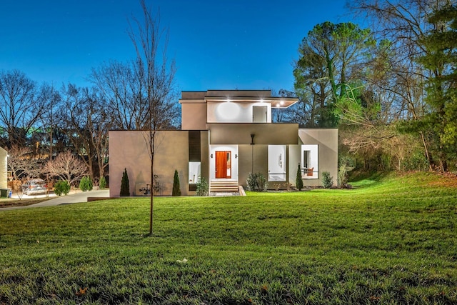 modern home with a front yard and stucco siding