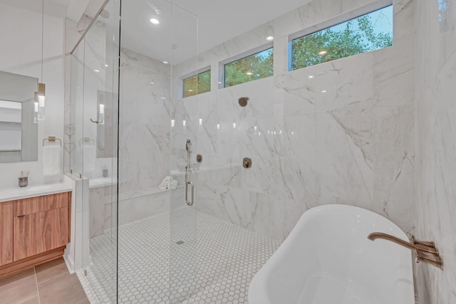 bathroom with vanity, tile walls, a soaking tub, a marble finish shower, and tile patterned floors