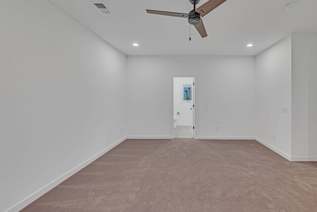 spare room with carpet floors, visible vents, ceiling fan, and baseboards