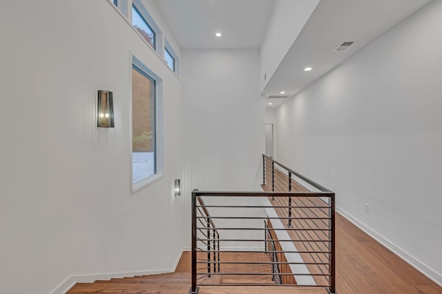 stairway featuring recessed lighting, wood finished floors, visible vents, and baseboards