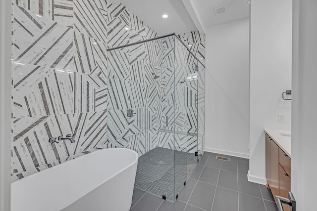 bathroom with visible vents, vanity, a soaking tub, a shower stall, and tile patterned floors