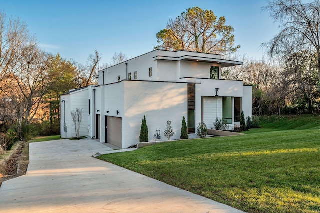 exterior space featuring concrete driveway, a lawn, an attached garage, and stucco siding