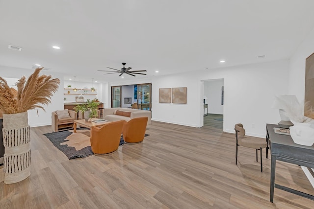 living room with light wood-style flooring, recessed lighting, a ceiling fan, baseboards, and visible vents