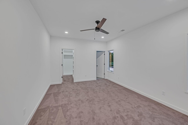 unfurnished bedroom featuring recessed lighting, carpet flooring, visible vents, baseboards, and a walk in closet