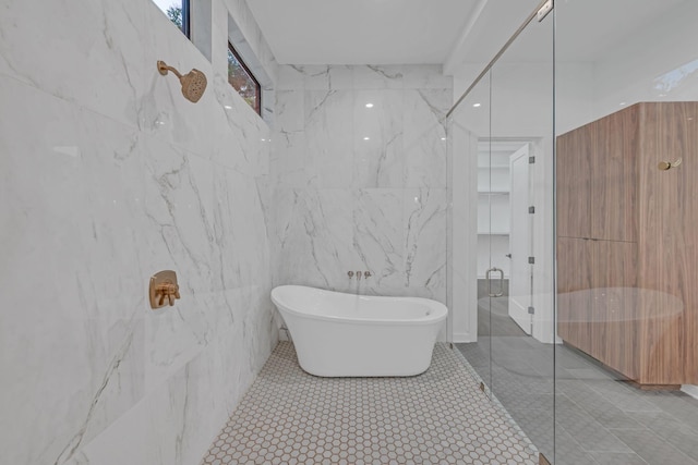 bathroom with a freestanding tub, tile walls, and a marble finish shower