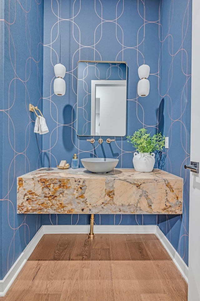 bathroom featuring wood finished floors, a sink, and baseboards