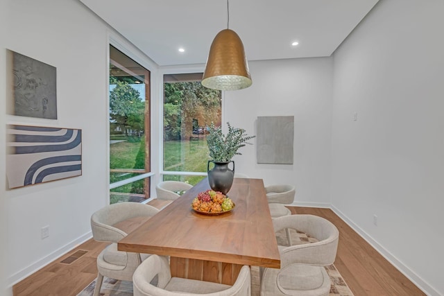 dining area with wood finished floors, visible vents, and a healthy amount of sunlight