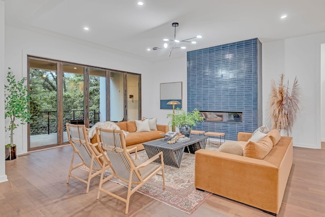 living area featuring french doors, a fireplace, recessed lighting, an inviting chandelier, and wood finished floors