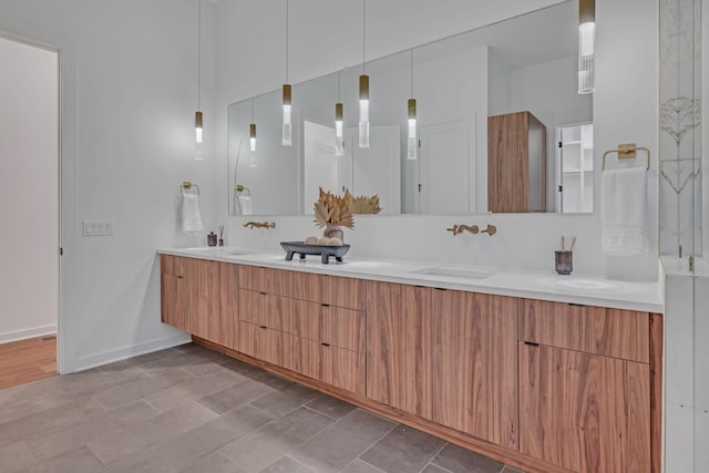 bathroom featuring double vanity, a sink, and baseboards