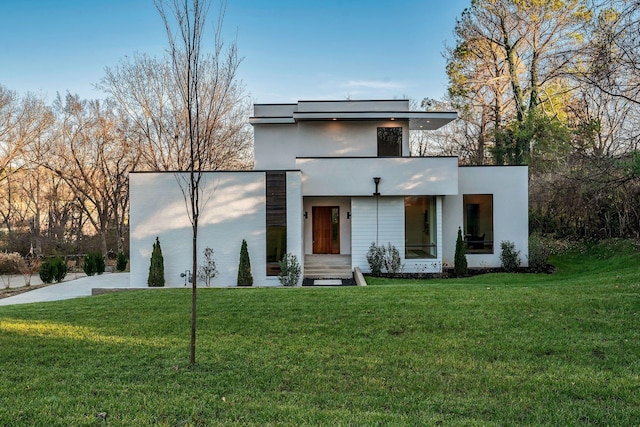 contemporary house with a front yard and stucco siding