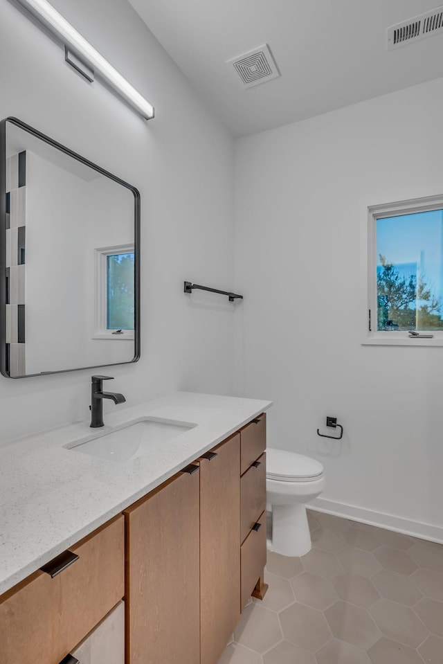 bathroom with toilet, vanity, visible vents, and tile patterned floors