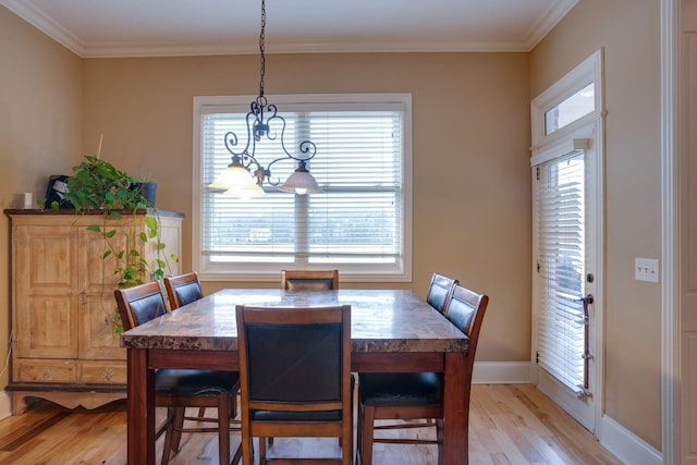 dining area with light hardwood / wood-style flooring and ornamental molding