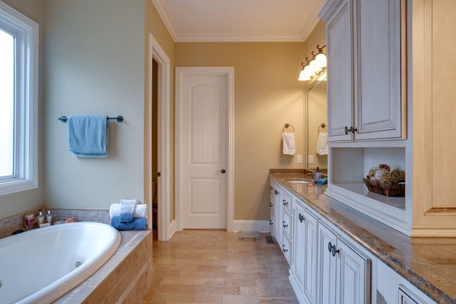 bathroom featuring tiled bath, vanity, and crown molding