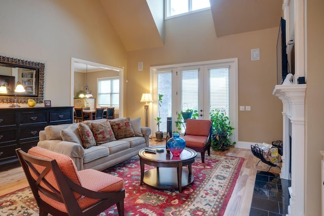 living room featuring french doors, wood-type flooring, and a towering ceiling