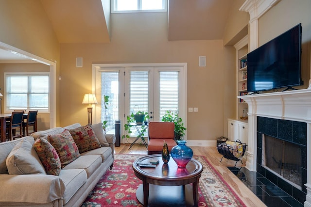 living room featuring built in shelves, a wealth of natural light, and hardwood / wood-style floors