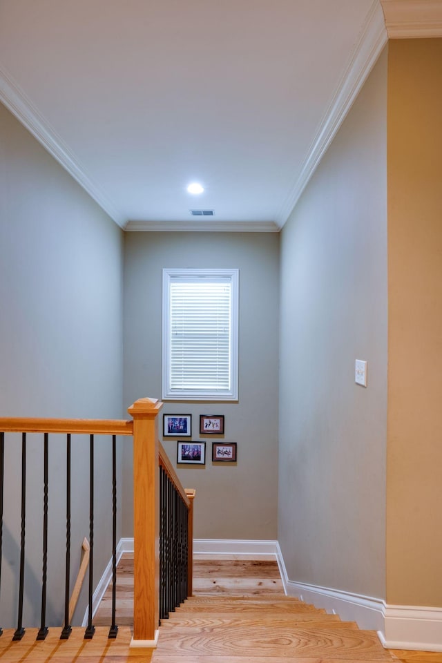 stairs featuring ornamental molding and hardwood / wood-style floors